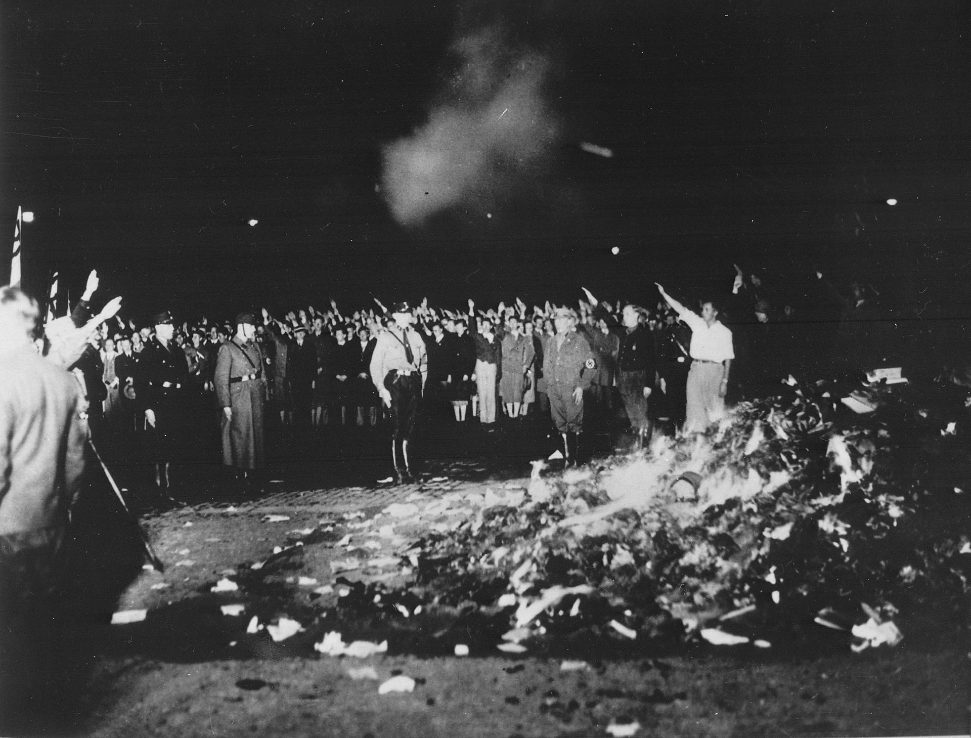 Thousands of books smoulder in a huge bonfire as Germans give the Nazi salute during the wave of book-burnings that spread throughout Germany.