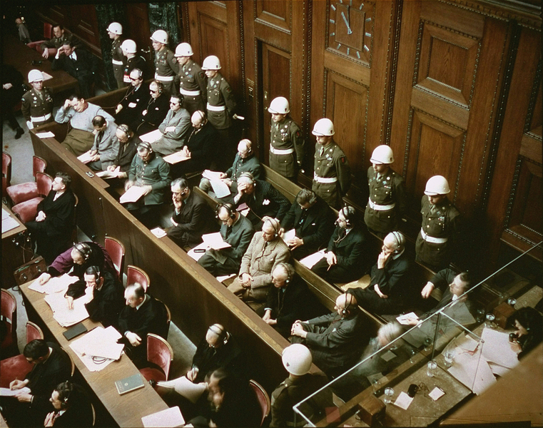 Rare color photo of the trial at Nuremberg, depicting the defendants, guarded by American Military Police